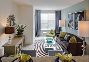 a living room with a couch and a table at Reveal Hackensack apartments